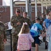 Airmen and civilians cheer students on their first day of school