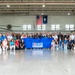 A large group of military personnel and civilians pose for a formal group photo inside a military helicopter hangar. They are holding a blue ESGR (Employer Support of the Guard and Reserve) banner, indicating this is an official ESGR event. Two military helicopters (appearing to be Apache attack helicopters) are visible in the background, along with an American flag and a South Carolina state flag.