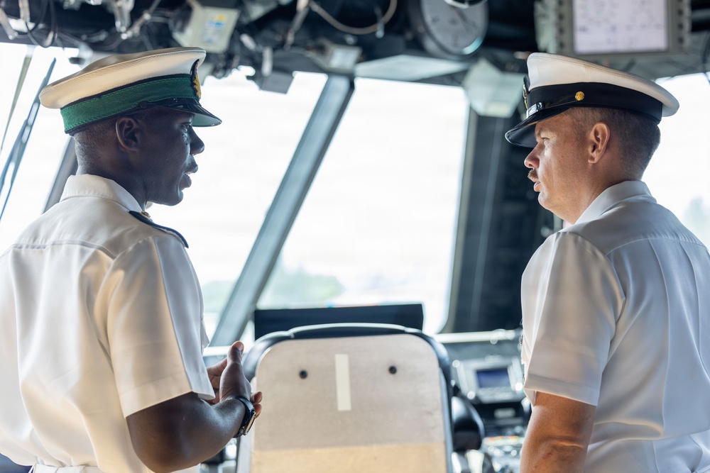 LCS 23 Command Senior Chief speaks wth RBDF midshipman in the ships pilot house.
