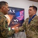 A U.S. Army soldier identified by the name tape 'JIMENEZ' is receiving a medal during what appears to be a multinational military ceremony. He is shaking hands with a soldier wearing a different camouflage pattern, likely from a Latin American military. The event appears connected to 'PANAMAX,' a multinational military exercise centered in Panama.