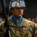 A U.S. Army soldier in ceremonial dress stands at attention during what appears to be an Officer Candidate School (OCS) ceremony. The soldier wears a distinctive chrome/silver helmet, blue ascot with OCS medallion, and OCP (Operational Camouflage Pattern) uniform while holding a rifle with bayonet. The name tape reads 'RODRIGUEZ' and unit tape reads 'O.C.S.'