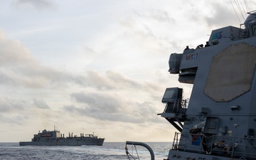USS Mustin conducts a replenishment-at-sea with USNS Wally Schirra