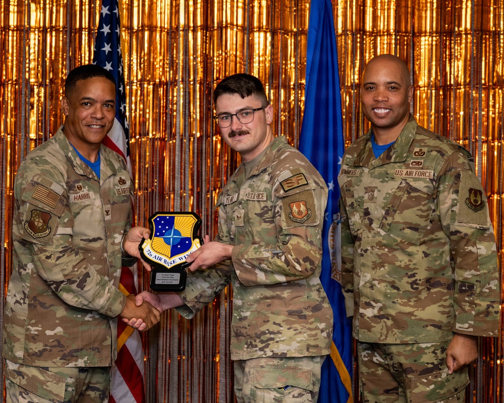 Three U.S. Air Force personnel pose for a formal award photo at what appears to be a recognition ceremony. The central figure is receiving a plaque bearing the '72d Air Base Wing' insignia, being presented by the individual on the left identified as 'HARRIS'. The individual on the right is identified as 'SUMMERS', and the recipient in the center wears an 'SF' (Security Forces) patch.