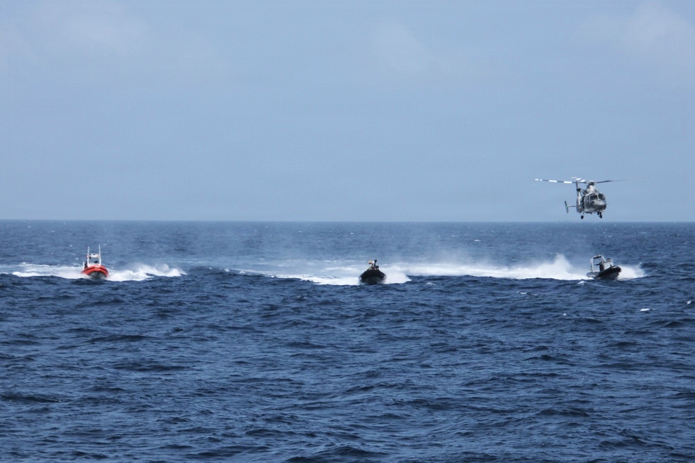 Coast Guard small boat and helicopter participating in a multinational pursuit exercise in 2026
