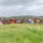 PANAMAX-26: V1/6, Partner forces conduct simulated air raid A large group of military personnel from multiple nations pose for a group photograph in an open grassy field with tropical vegetation in the background. Participants are holding several national and military flags, indicating a multinational military exercise or joint training event. The flags visible include those of Mexico, the United States, Panama, Ecuador, and a U.S. Marine Corps flag.