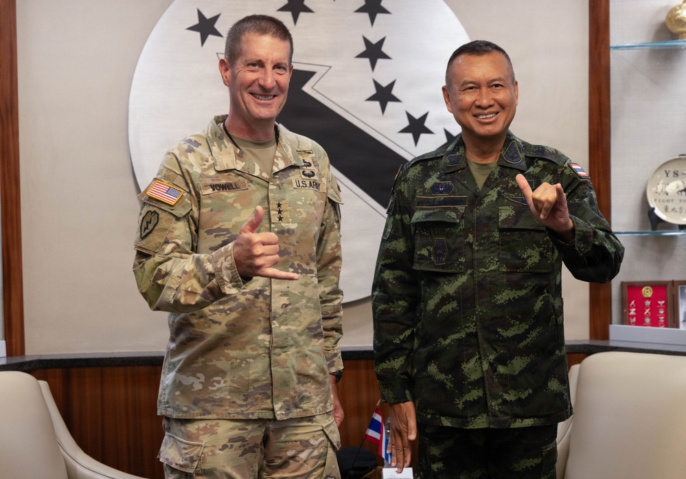 Two military officers are posing together for a formal photo, both making 'shaka' or thumbs-up hand gestures and smiling. The officer on the left wears a U.S. Army OCP (Operational Camouflage Pattern) uniform with the name tape 'VOWELL' and four-star rank insignia, along with a U.S. flag patch. The officer on the right wears a Thai military digital camouflage uniform with a Thai flag patch, suggesting this is a bilateral military meeting.