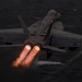 A carrier-based twin-engine jet fighter, marked with the number 211 on both wings, is captured launching at low altitude over open ocean in low-light conditions. Both engines are visibly in full afterburner, producing bright orange flame plumes. The aircraft appears to be in a steep climb shortly after catapult launch from a naval vessel.