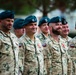 A group of Polish military personnel standing in formation during what appears to be a formal ceremony or parade. The soldiers are wearing Polish Armed Forces desert camouflage uniforms with Polish flag patches and teal/green berets bearing the Polish eagle insignia. Several soldiers have medals or ribbons pinned to their chests, indicating a decorations or awards ceremony.
