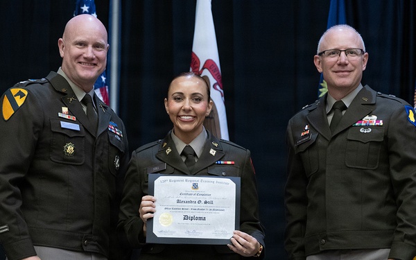 Three U.S. Army personnel pose for a formal photograph at a military graduation ceremony. The central figure, a female soldier, holds a diploma from the 120th Regiment Regional Training Institute, Officer Candidate School, awarded to 'Alexandra O. Still.' Two senior male officers flank her on either side.