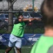 A player wearing a green vest/bib over a black shirt is captured mid-throw or follow-through motion on an outdoor sports court. The event appears to be the 'CAFIC Cup Panama' based on visible sponsorship banners. Puma branding is also visible on a banner in the background.