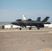 A U.S. Marine Corps F-35B Lightning II stealth fighter jet is taxiing on a runway at a military airbase. The aircraft's canopy is open and it bears tail code 'WF' with the number '562' visible on the fuselage, indicating it belongs to VMFAT-501 or a similar Marine F-35 training squadron. Military hangars and aircraft shelters are visible in the background.