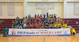 PIEFriends Summer Camp group photo at Camp Humphreys gymnasium, South Korea, 2026