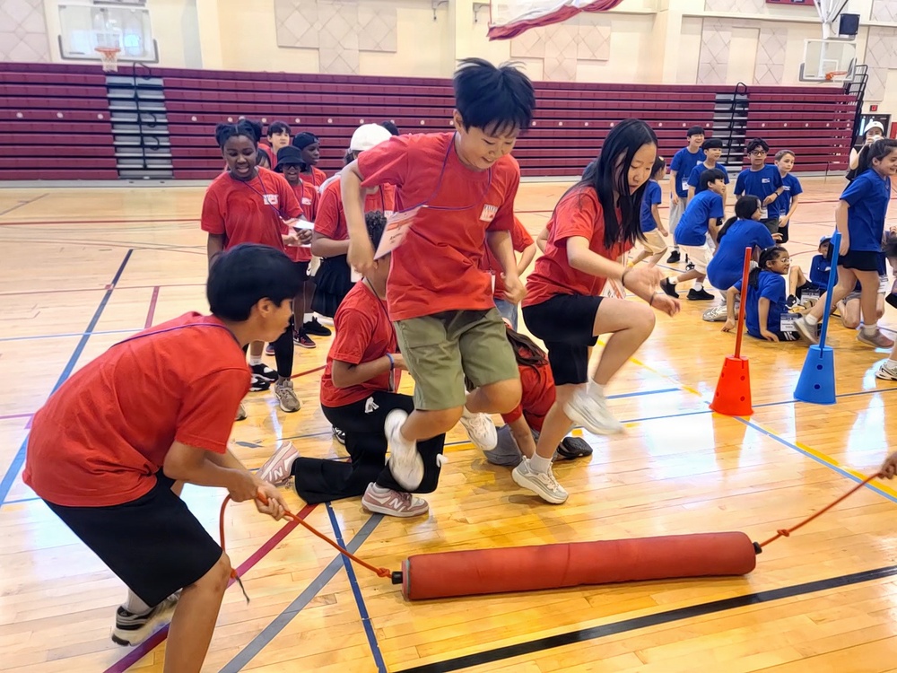 Students compete in team relay race during youth sports event at Camp Humphreys gymnasium