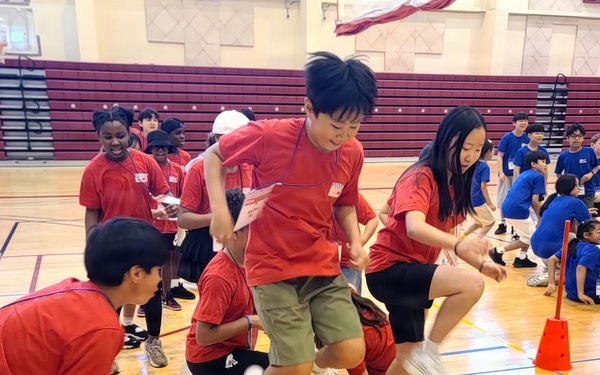 Students compete in team relay race during youth sports event at Camp Humphreys gymnasium