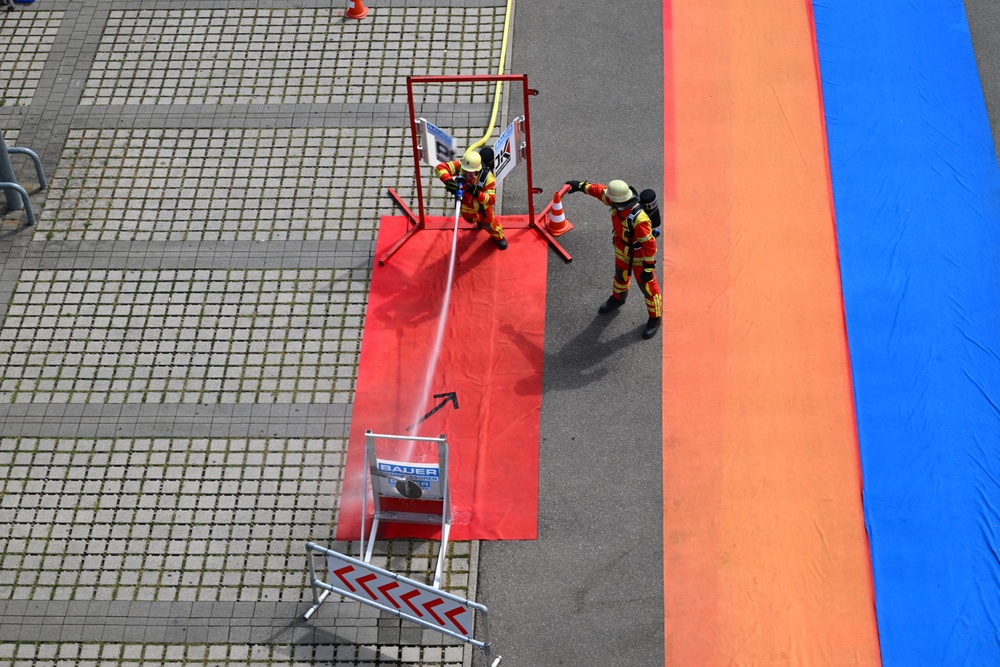 Firefighters conduct hose accuracy drill during competition exercise at outdoor training facility
