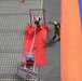 Firefighters conduct hose accuracy drill during competition exercise at outdoor training facility