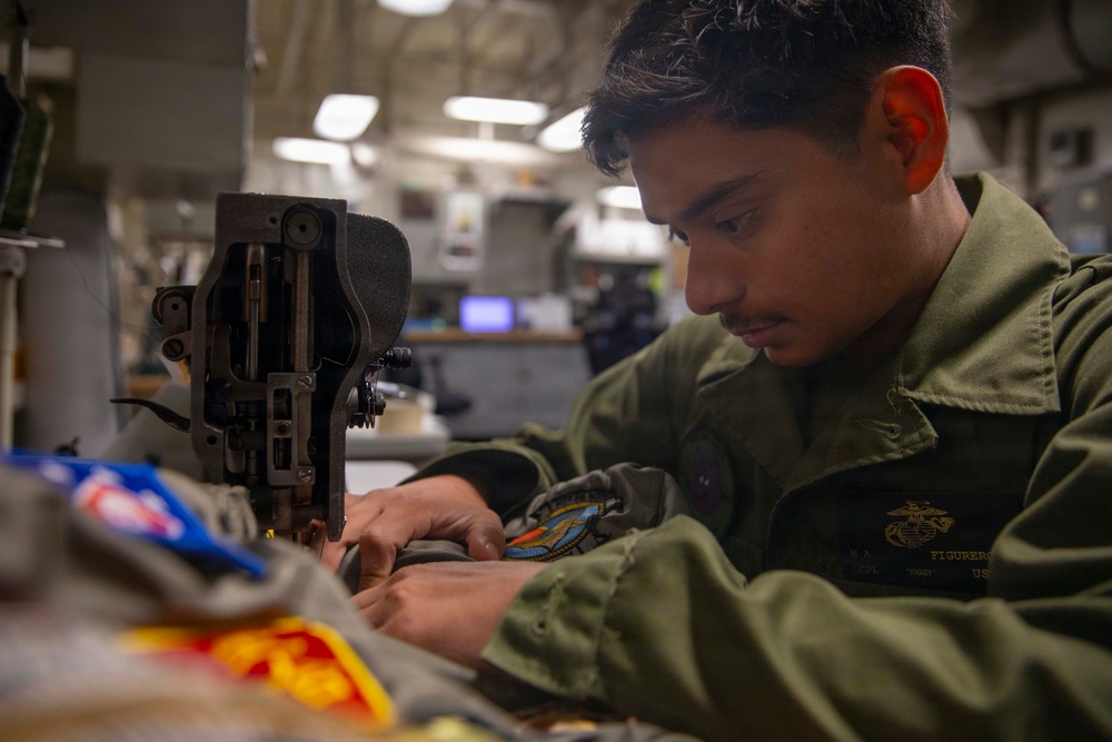 U.S. Marine Sews Squadron Patch on Flight Jacket