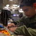 U.S. Marine Sews Squadron Patch on Flight Jacket