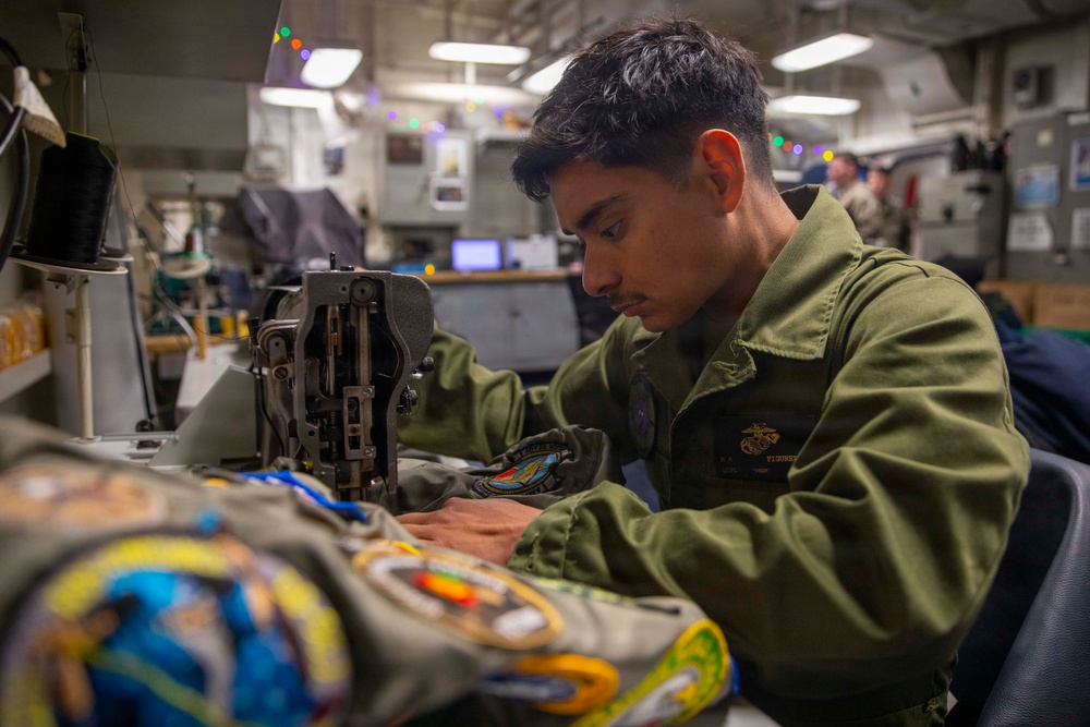 U.S. Marine Sews Squadron Patch on Flight Jacket