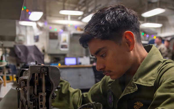 U.S. Marine Sews Squadron Patch on Flight Jacket
