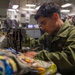 U.S. Marine Sews Squadron Patch on Flight Jacket