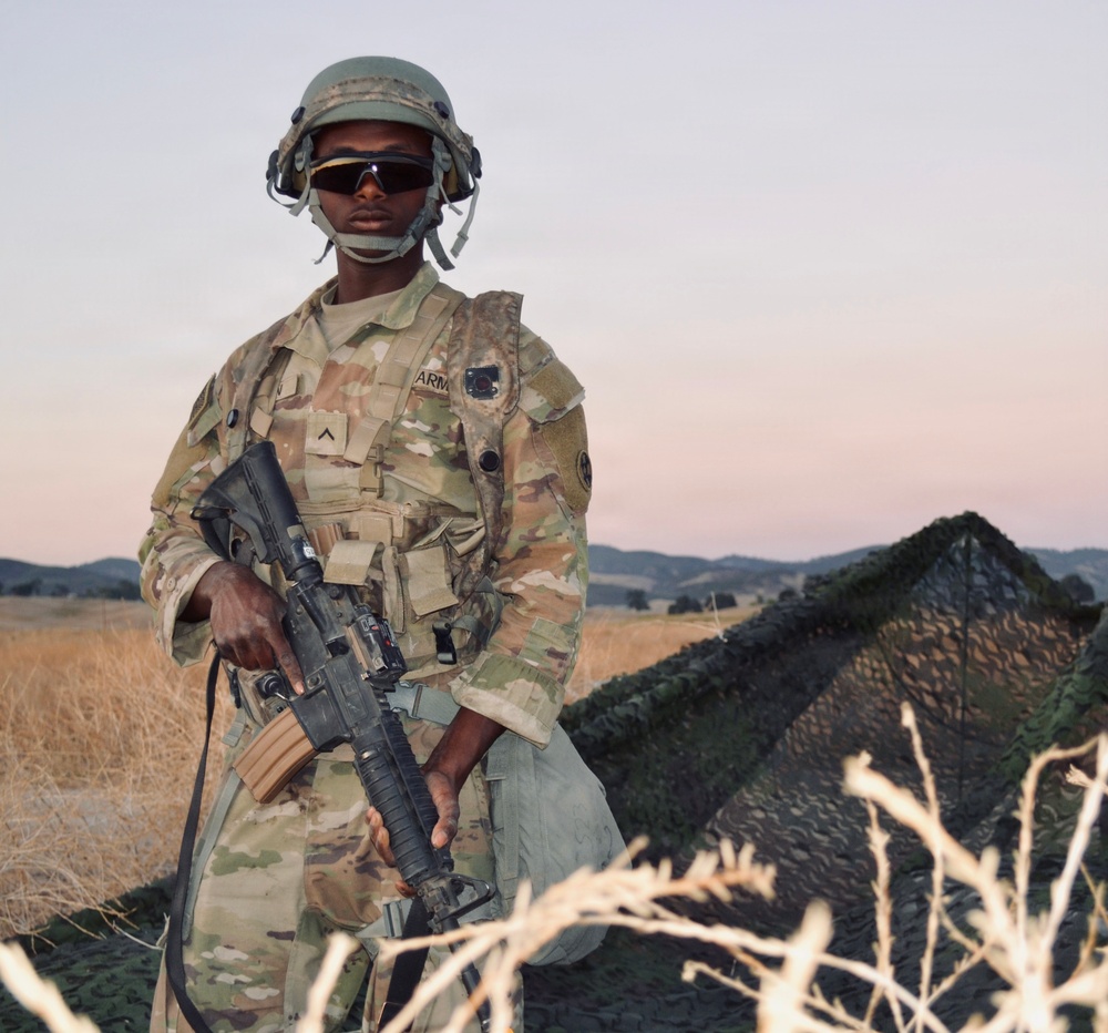Soldier stands guard at entry control point during CSTX 26 at Fort Hunter‑Liggett
