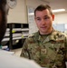 A U.S. Air Force Staff Sergeant wearing OCP (Operational Camouflage Pattern) uniform is engaged in a conversation with another individual whose back is to the camera. The name tape reads 'WARD' and the rank insignia indicates Staff Sergeant. The setting appears to be an administrative or office environment on a military installation.