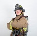 A firefighter in full turnout gear poses with arms crossed against a plain white background. The subject wears a black helmet labeled 'ARFF' and 'MCAS Miramar' with 'Lead Firefighter' designation, indicating affiliation with Aircraft Rescue and Firefighting at Marine Corps Air Station Miramar. The professional portrait-style photo captures the firefighter in complete personal protective equipment including an SCBA tank.