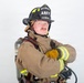A firefighter in full turnout gear poses against a white background with arms crossed. The helmet identifies them as a 'Lead Firefighter' with 'ARFF' (Aircraft Rescue and Firefighting) designation at 'MCAS Miramar'. The subject is equipped with a Scott SCBA (Self-Contained Breathing Apparatus) tank on their back.