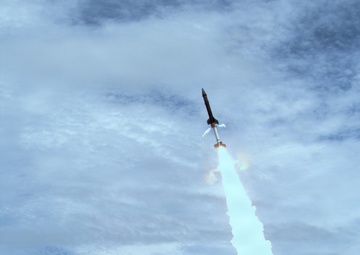 A rocket is captured mid-launch at a test or research facility, ascending steeply with a bright white-blue exhaust plume and large billowing smoke cloud at the base. The timestamp embedded in the image reads Thursday, August 6, 2026 at 13:01:41.047, with a counter reading 301.20 S. Ground-based tracking equipment and launch infrastructure are visible in the foreground.