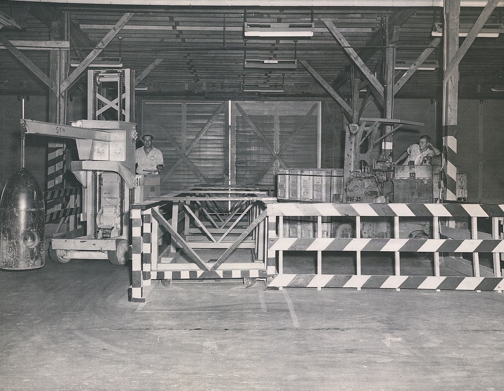 Historical McAlester Army Ammunition Plant photo - circa 1940's- people working on bomb line-moving bomb body with tug