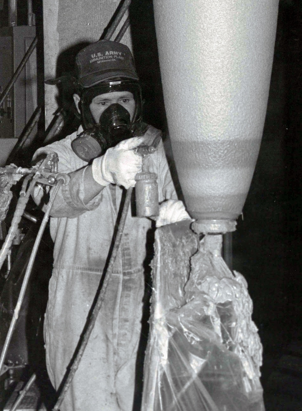 Historical McAlester Army Ammunition Plant photo - employee applying elbow stripe to bomb.