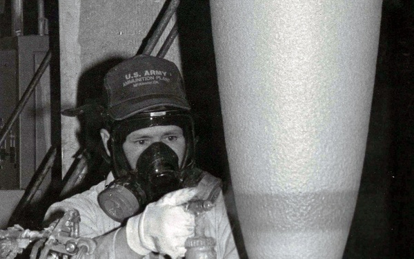 Historical McAlester Army Ammunition Plant photo - employee applying elbow stripe to bomb.