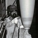 Historical McAlester Army Ammunition Plant photo - employee applying elbow stripe to bomb.