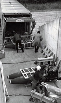 Historical McAlester Army Ammunition Plant photo - employees on loading dock inspecting bomb shipment
