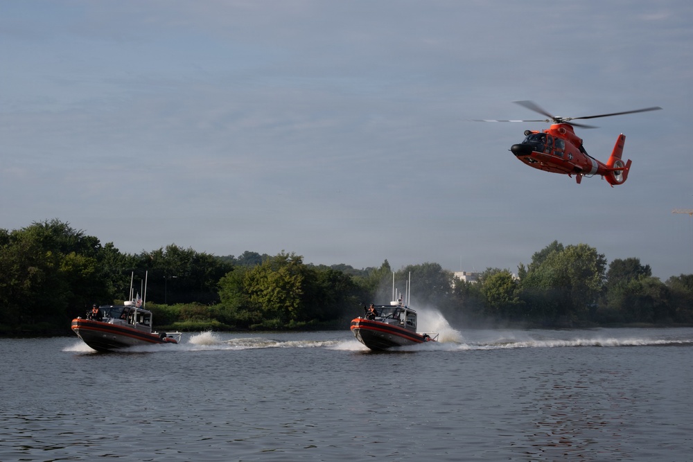 U.S. Coast Guard MH-65 Dolphin helicopter and response boats conduct joint patrol operations on inland waterway