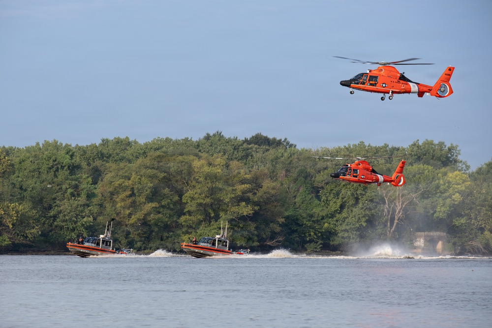 U.S. Coast Guard MH-65 Dolphin helicopters and response boats conduct joint operations on inland waterway