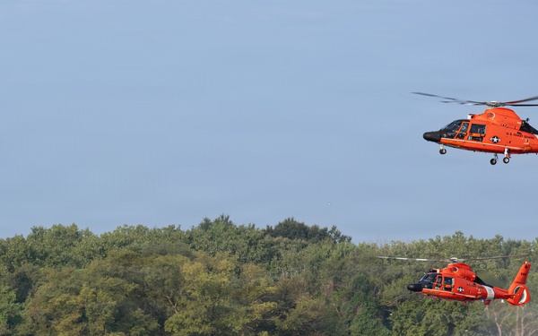 U.S. Coast Guard MH-65 Dolphin helicopters and response boats conduct joint operations on inland waterway