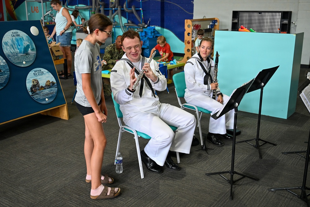 Musician 3rd Class Dean Brady demonstrates for audience member at Wise Wonders Museum in Billings