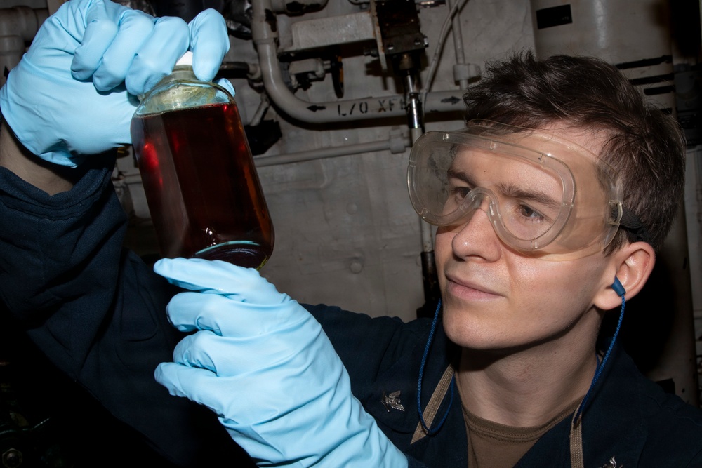 Sailor Inspects Lube Oil Sample Aboard USS Delbert D. Black