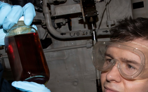 Sailor Inspects Lube Oil Sample Aboard USS Delbert D. Black