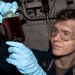 Sailor Inspects Lube Oil Sample Aboard USS Delbert D. Black