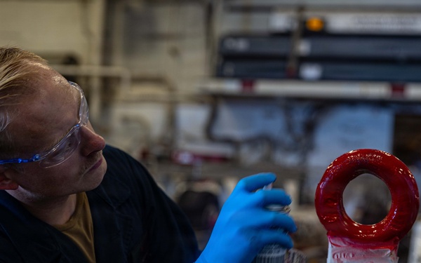 U.S. Navy Sailor Repaints Aircraft Tow