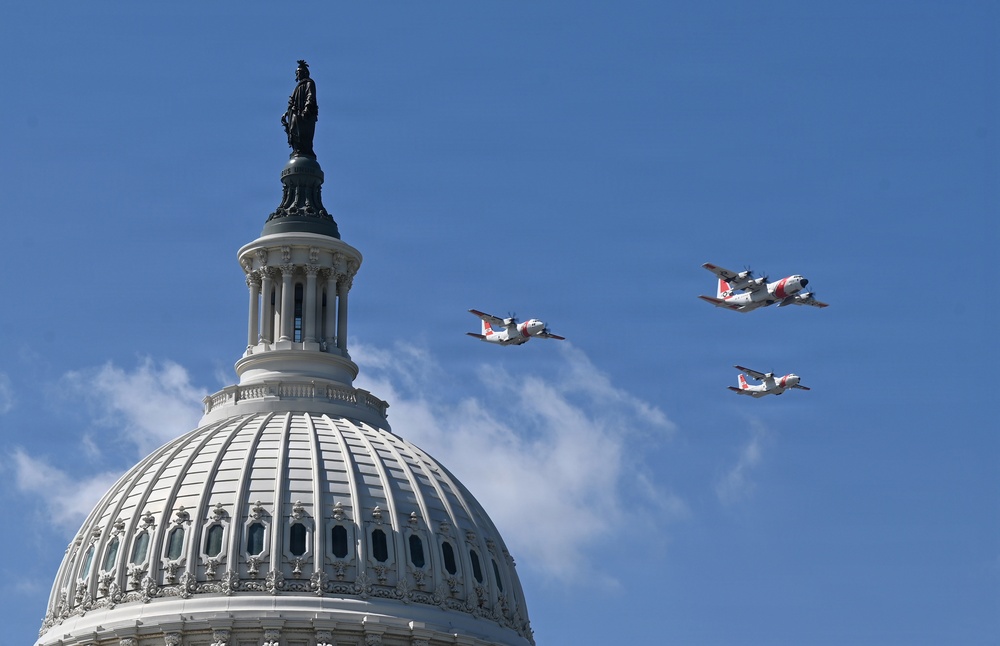 Three turboprop aircraft with red and white markings consistent with U.S. Coast Guard livery fly in formation over the dome of the United States Capitol building in Washington, D.C. The Statue of Freedom is clearly visible atop the Capitol dome. This appears to be a ceremonial flyover, likely associated with an inauguration or national event.