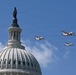 Three turboprop aircraft with red and white markings consistent with U.S. Coast Guard livery fly in formation over the dome of the United States Capitol building in Washington, D.C. The Statue of Freedom is clearly visible atop the Capitol dome. This appears to be a ceremonial flyover, likely associated with an inauguration or national event.
