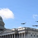 Three U.S. military aircraft are conducting a flyover above the United States Capitol building in Washington, D.C. The formation includes what appear to be a B-1B Lancer, a B-52 Stratofortress, and a B-2 Spirit stealth bomber flying in close proximity. The scene suggests a ceremonial or commemorative flyover event under clear blue skies.