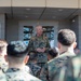 A senior U.S. Marine Corps officer addresses a group of Marines in camouflage uniforms outdoors at what appears to be a military installation. Two signs are visible in the background: one for 'Marine Rotational Force Darwin' featuring Australian and American flag imagery, and another for 'Headquarters Northern Command.' The setting suggests this is a briefing or address at a joint U.S.-Australian military facility in Darwin, Australia.