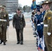 A formal military honor guard inspection ceremony is taking place outdoors, likely in Canberra, Australia. A senior US Marine Corps officer wearing a peaked cap and extensive medal ribbons is being escorted by an Australian Army officer carrying a sword. Personnel from multiple Australian military branches — Army, Air Force, and Navy — are standing at attention in formation.