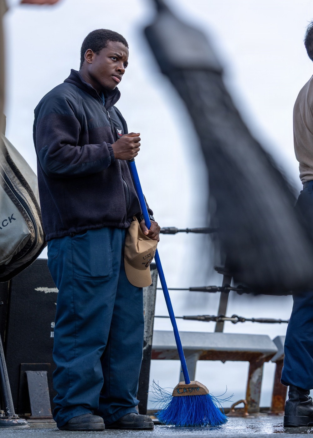 Sailor Sweeps Deck Aboard USS Ross (DDG 71)