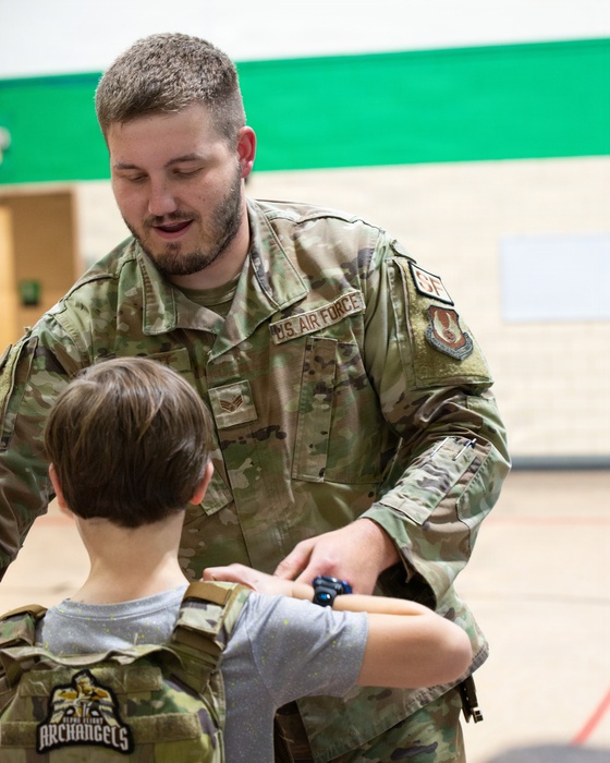 Child tries on military police vest.